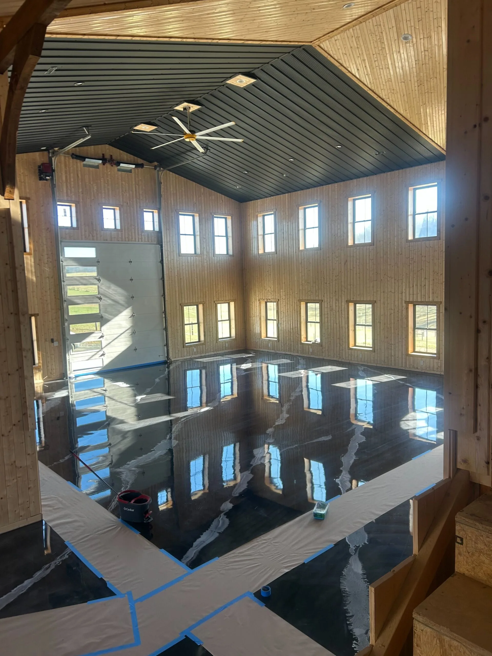 A captivating photograph of a modern building featuring a sleek, polished floor that reflects sunlight streaming through large, expansive windows. The bright natural light enhances the clean and contemporary design, creating an inviting and sophisticated atmosphere.