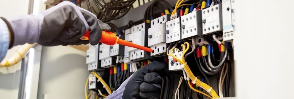 Electrician installing cables in an electrical panel for the "Wiring Services" section
